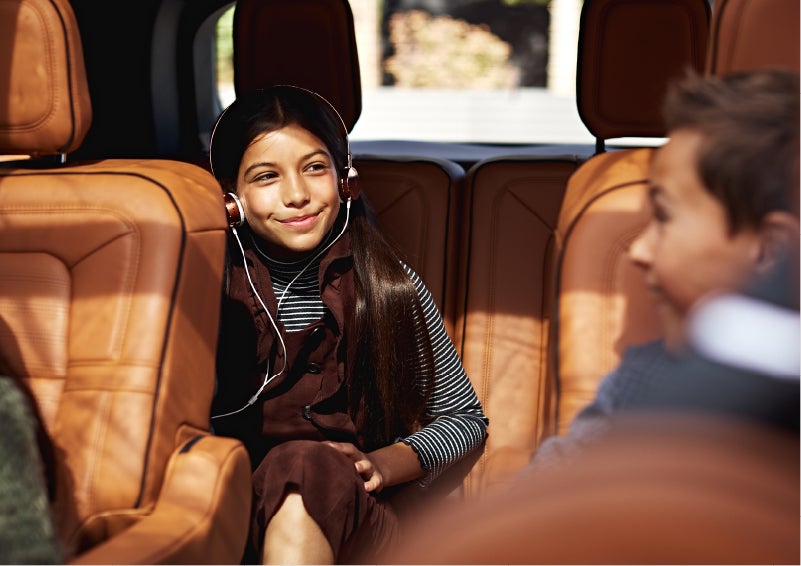 Two young people are shown comfortably seated in the second and third rows of a Lincoln Aviator® SUV | Green Lincoln in Greensboro NC