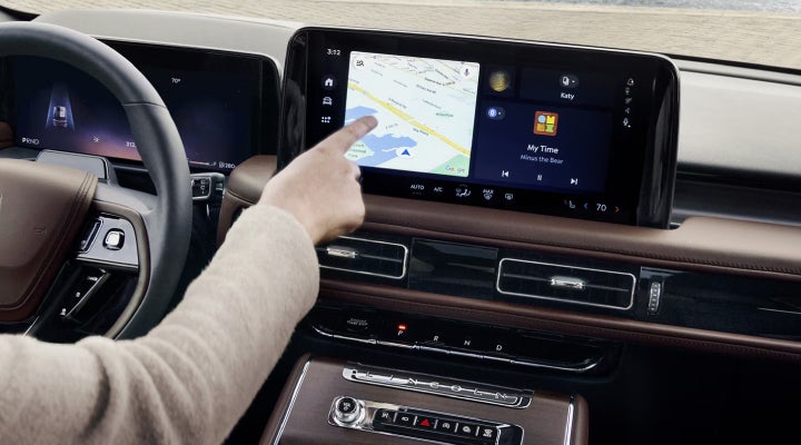 A person is tapping the center display touchscreen of a 2026 Lincoln Aviator® SUV. | Green Lincoln in Greensboro NC