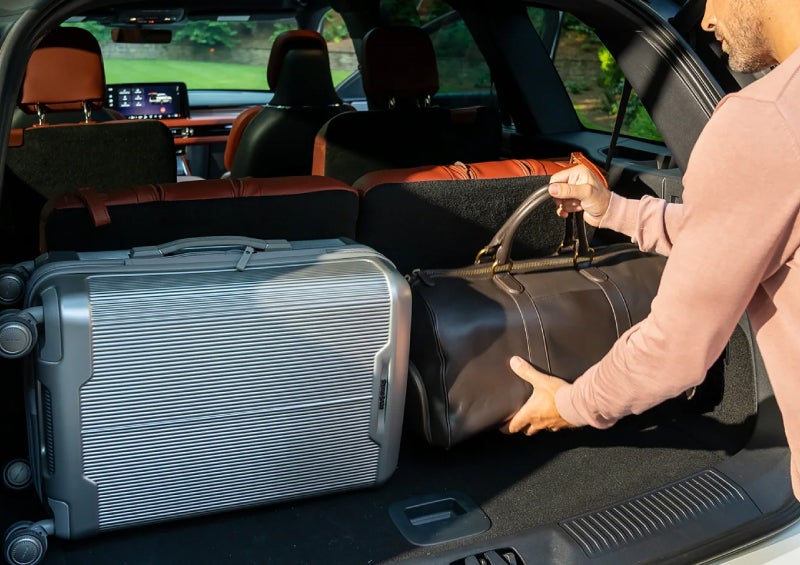 A man loads luggage into the rear of a 2026 Lincoln Aviator® SUV through the opened rear liftgate. | Green Lincoln in Greensboro NC