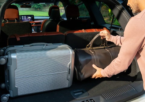 A man loads luggage into the rear of a 2026 Lincoln Aviator® SUV through the opened rear liftgate. | Green Lincoln in Greensboro NC