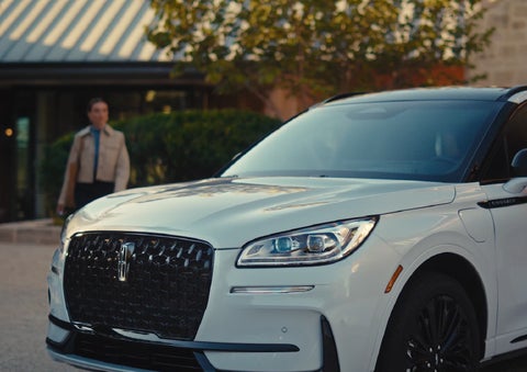 A person approaches a 2026 Lincoln Corsair® SUV as the Lincoln Embrace light sequence takes place. | Green Lincoln in Greensboro NC