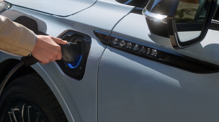 A hand is plugging in a 2026 Lincoln Corsair® Grand Touring Plug-in Hybrid SUV. | Green Lincoln in Greensboro NC