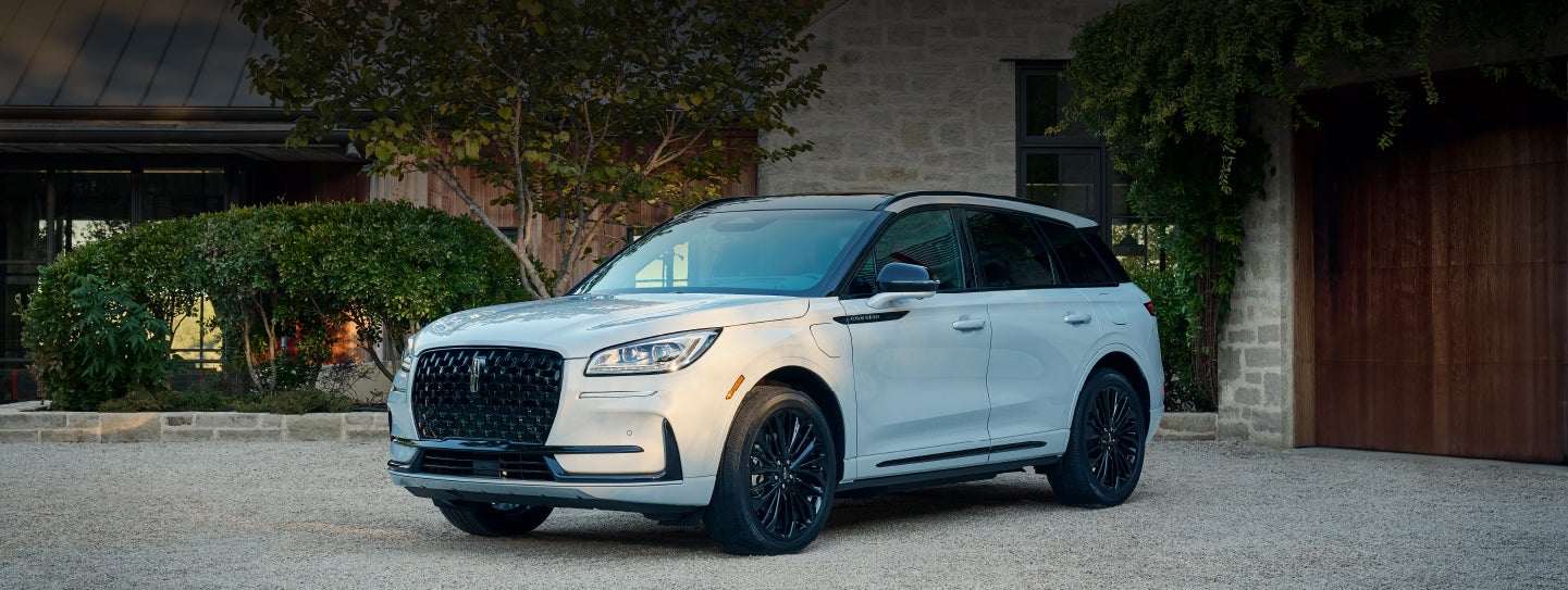 A 2026 Lincoln Corsair® SUV is parked in front off a luxury home. | Green Lincoln in Greensboro NC