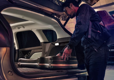 A man is shown loading cargo into the rear of a 2026 Lincoln Corsair® SUV with the second-row seats folded flat. | Green Lincoln in Greensboro NC