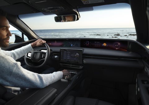 A driver of a parked 2026 Lincoln Nautilus® SUV takes a relaxing moment at a seaside overlook while inside his Nautilus. | Green Lincoln in Greensboro NC