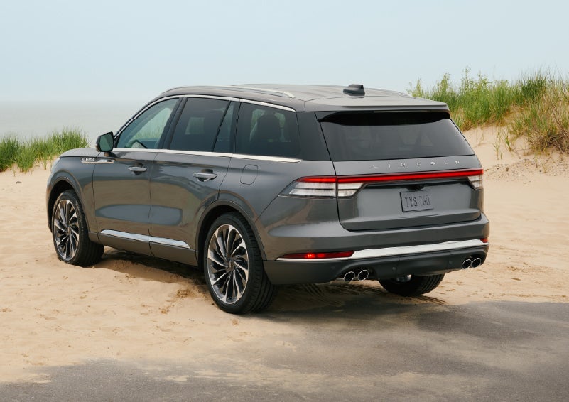 A 2027 Lincoln Aviator® SUV is parked next to sand dunes. | Green Lincoln in Greensboro NC