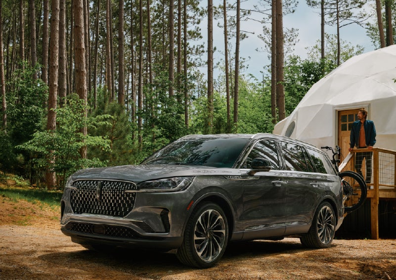 A 2027 Lincoln Aviator® is parked next to a high end glamping site. | Green Lincoln in Greensboro NC