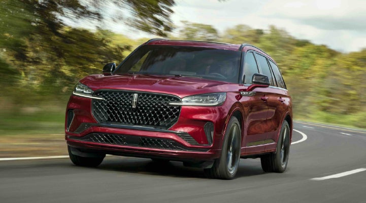 A 2027 Lincoln Aviator® SUV is being driven on a country road | Green Lincoln in Greensboro NC