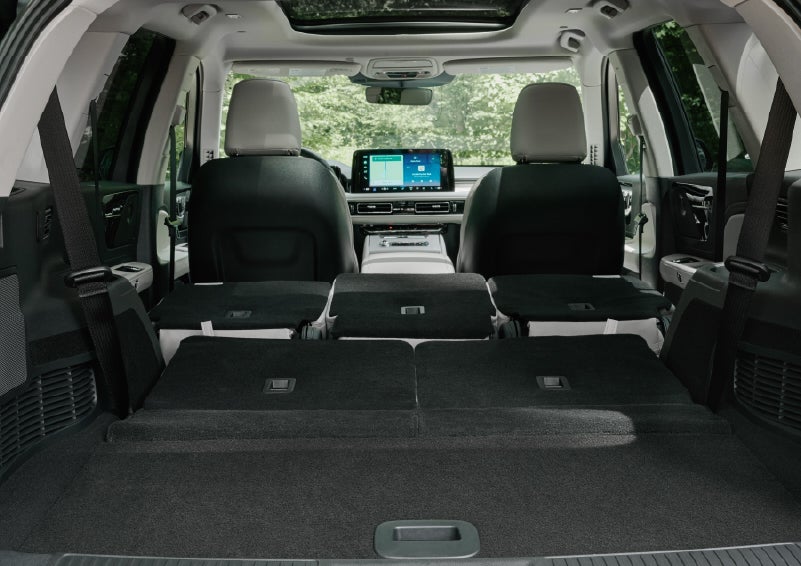 A rear to front view of the interior of a 2027 Lincoln Aviator® Black Label™ SUV shows the third and second rows folded flat | Green Lincoln in Greensboro NC
