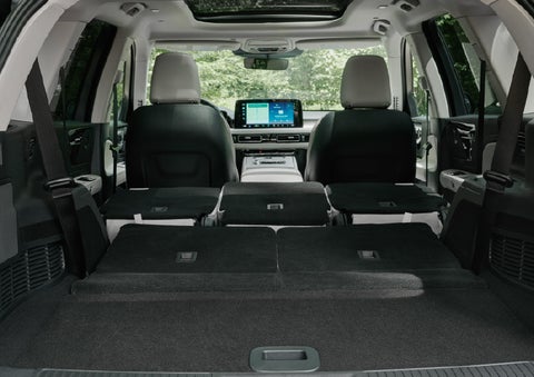 A rear to front view of the interior of a 2027 Lincoln Aviator® Black Label™ SUV shows the third and second rows folded flat | Green Lincoln in Greensboro NC