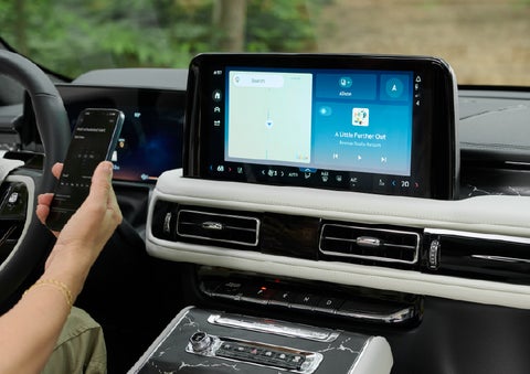 A person pairs thier phone with the center touchscreen of a 2027 Lincoln Aviator® Black Label™ SUV | Green Lincoln in Greensboro NC